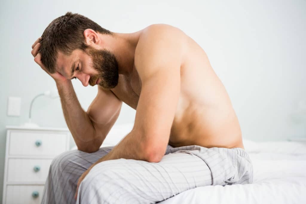 Depressed man in bed.