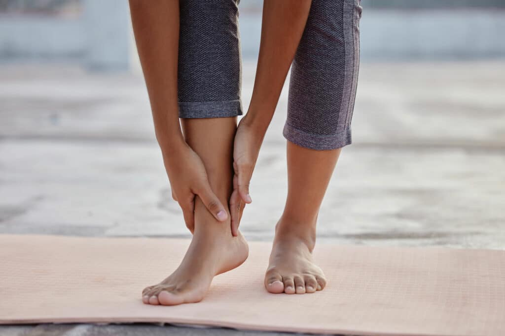 Feet of a woman in yoga mat.