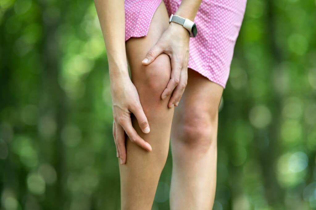 Woman holding her knee due to pain.